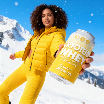 Person in yellow winter outfit holding a can of Cryoteam Whey protein powder in a snowy mountain setting